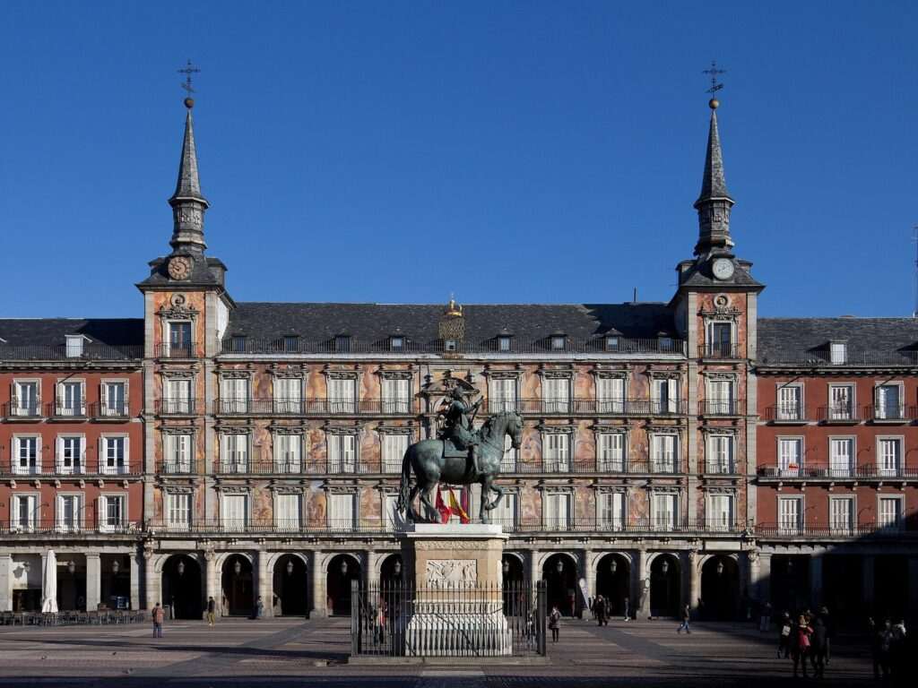 Fachada de la Casa de la Panadería en la Plaza Mayor de Madrid, con la estatua ecuestre de Felipe III en primer plano.